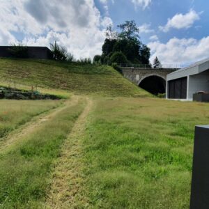 Gebäude neben Eisenbahntunnel und Wiese