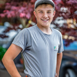 Lächelnder Teenager im Gartenarbeitsoutfit.