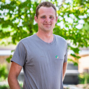 Person im Garten stehend vor Bäumen.