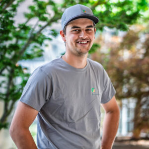 Mann mit grauem T-Shirt und Kappe im Freien