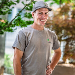 Lächelnder Mann mit Basecap im Garten