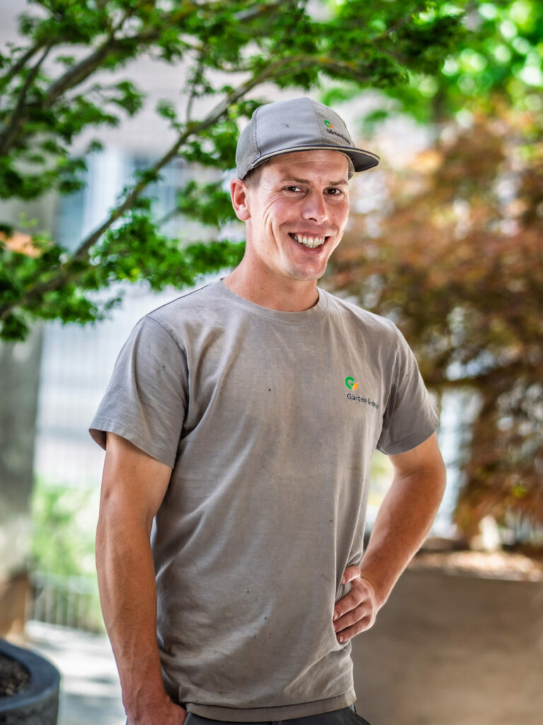 Lächelnder Mann mit Basecap im Garten
