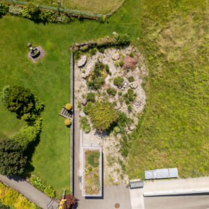 Drohnenansicht eines Gartens mit Rasen und Steingarten.
