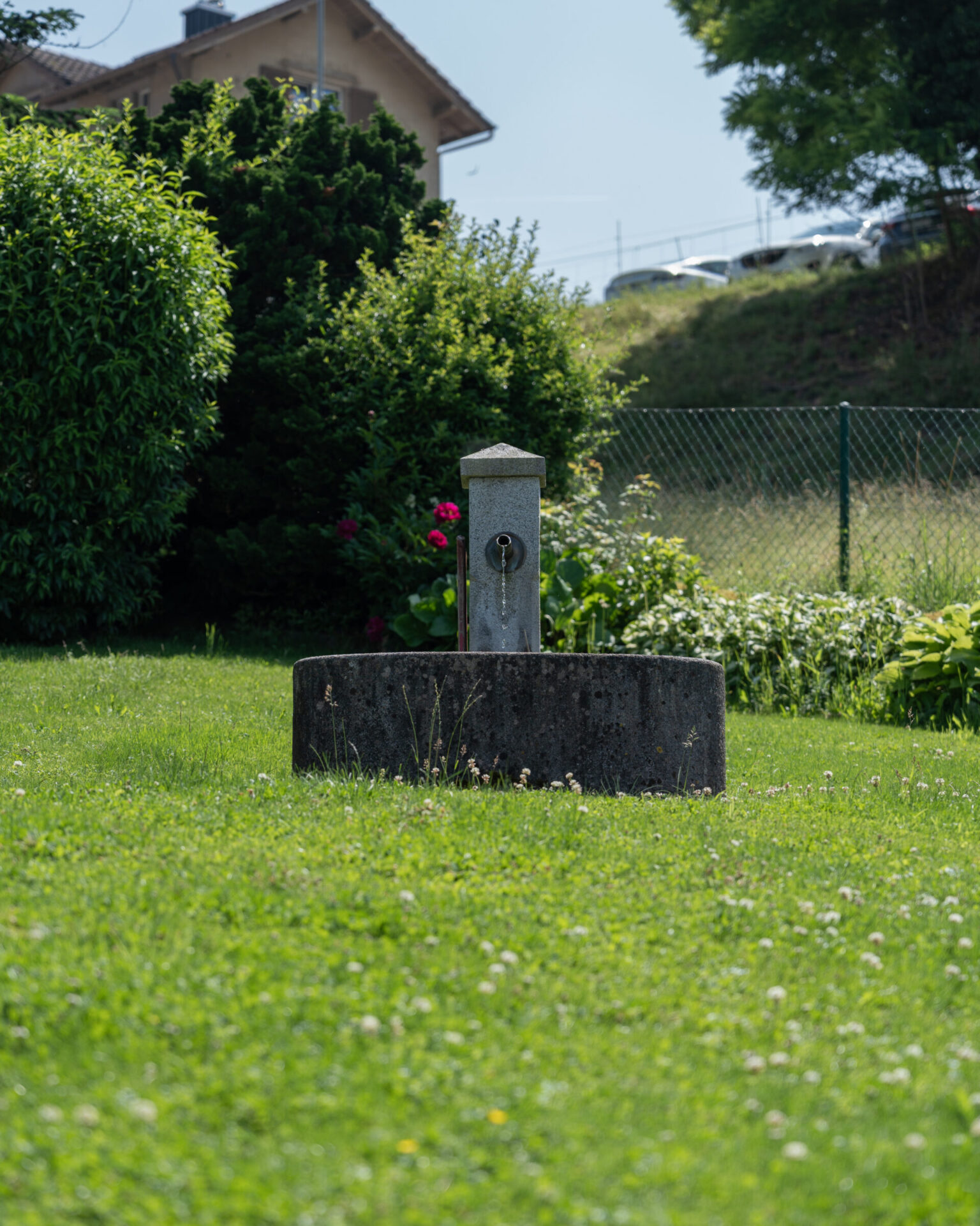 Kleiner Wasserbrunnen im grünen Garten