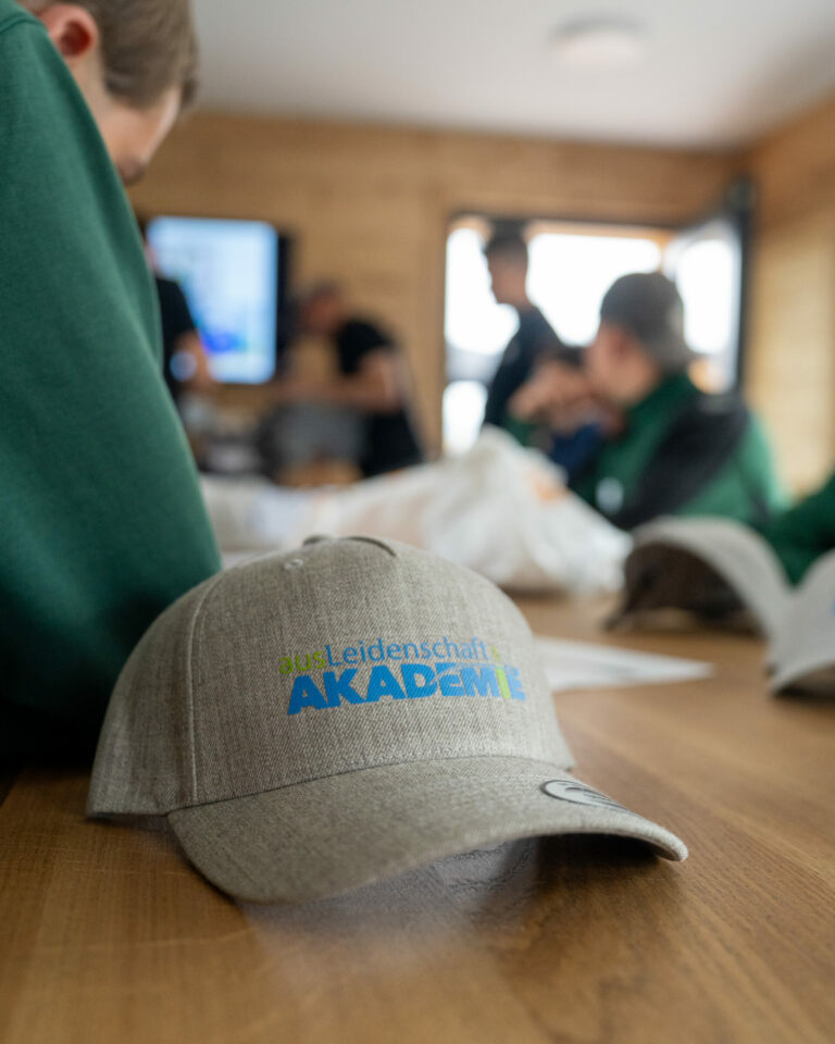 Kappe mit Akademie-Logo auf einem Tisch.