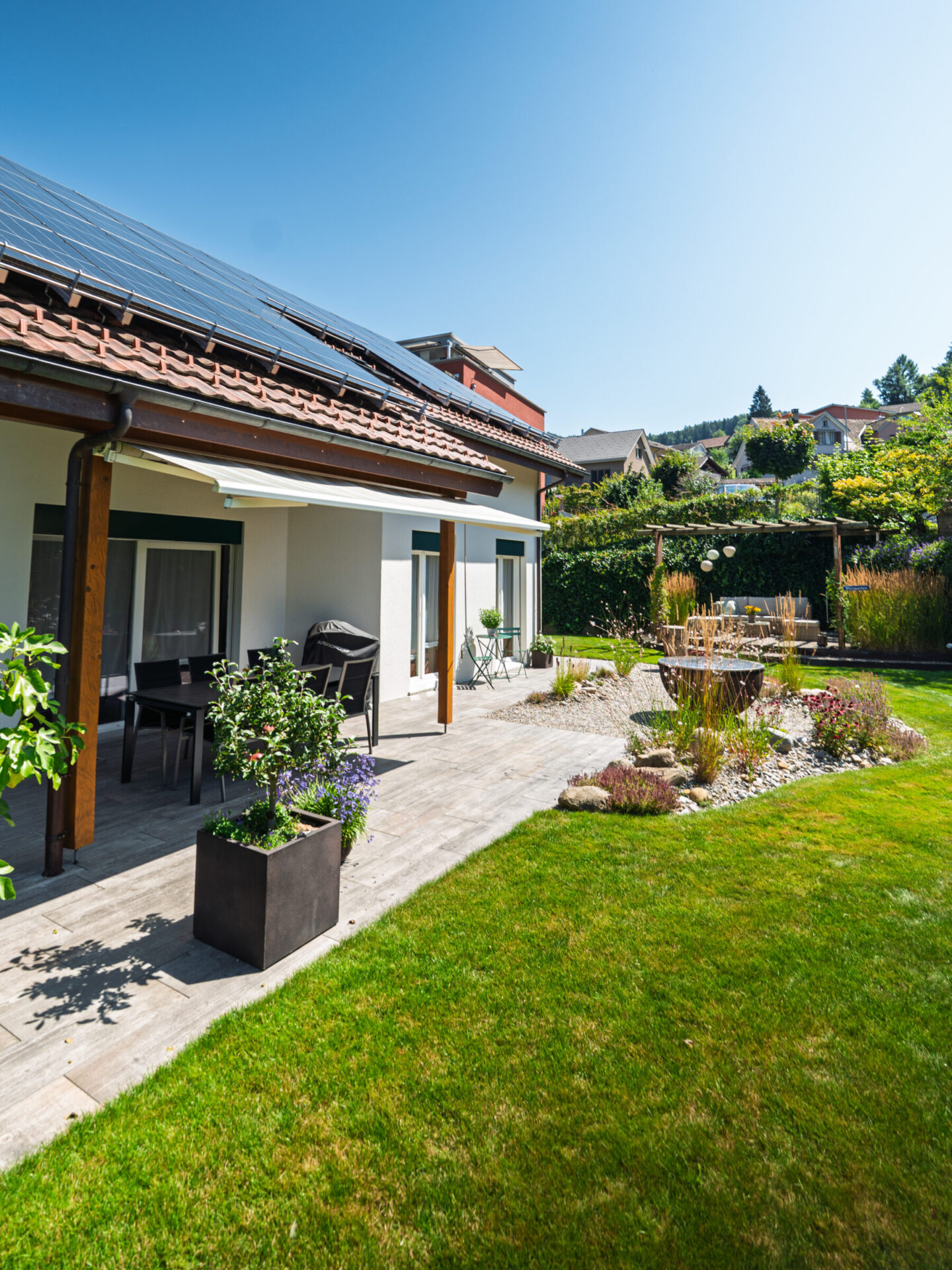 Haus mit Solarpanels und Garten