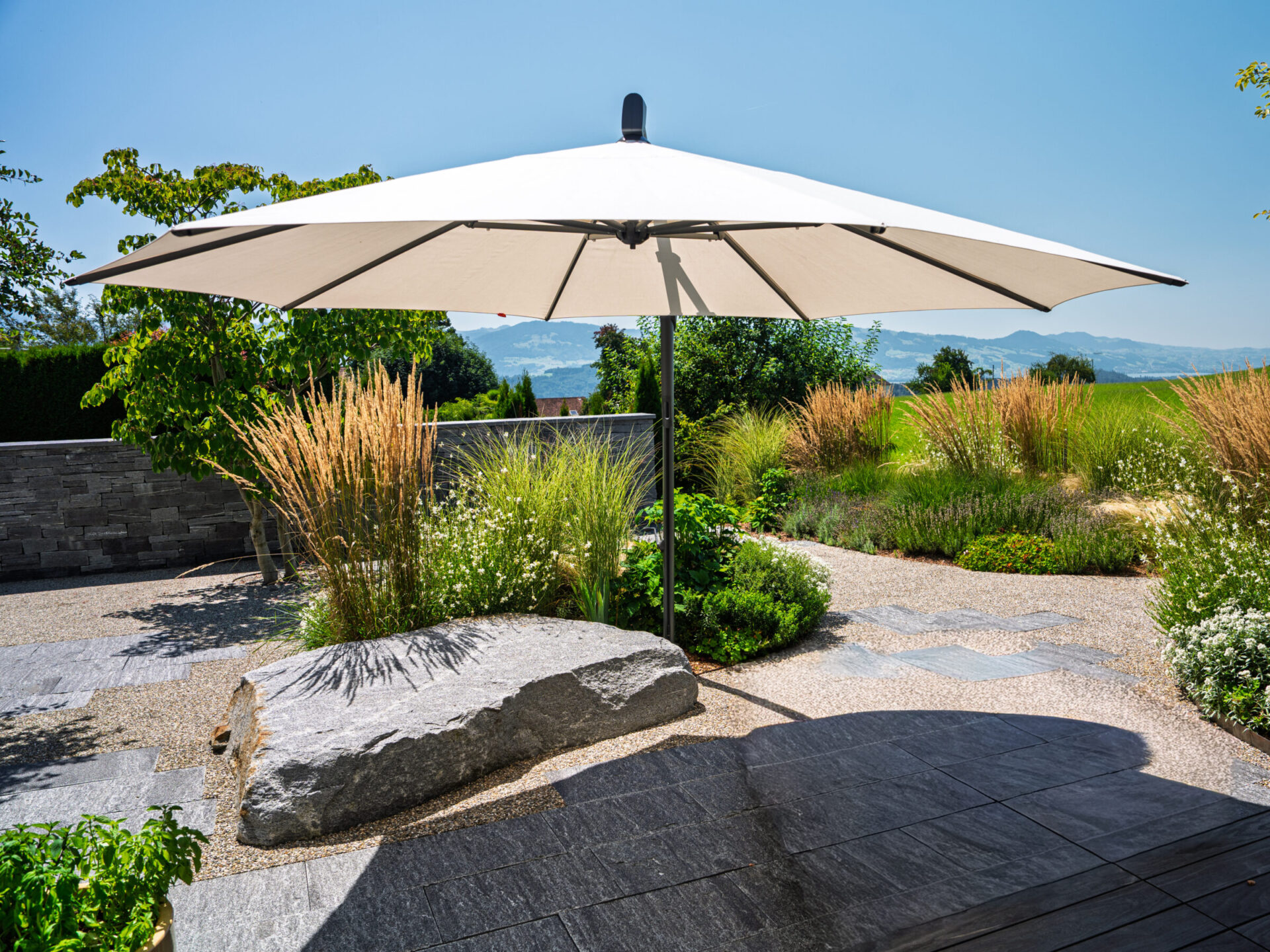Sonnenschirm im Garten mit Kiesweg
