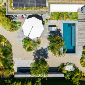 Luftansicht Garten mit Pool und Sonnenschirm.