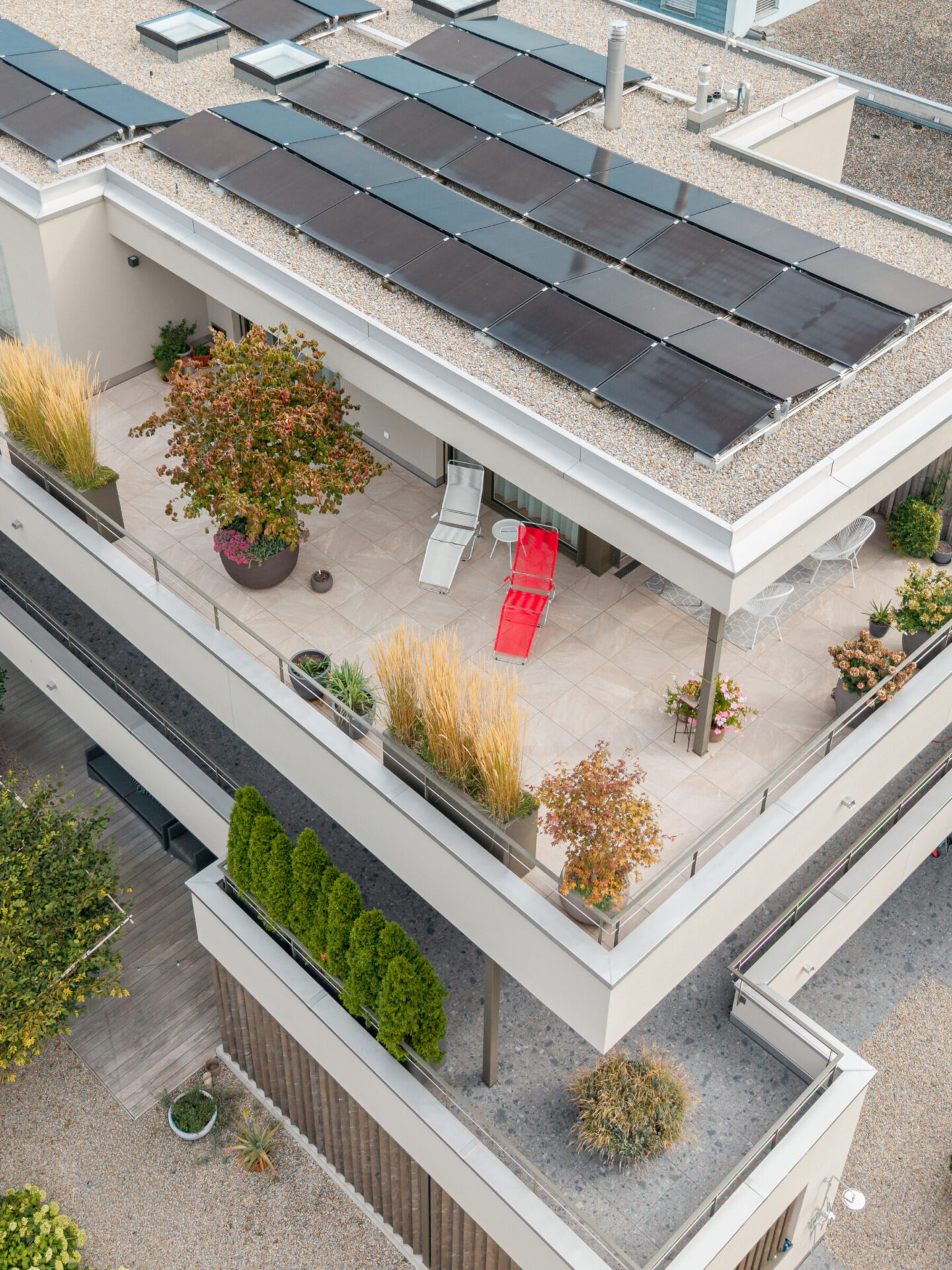 Dachterrasse mit Solarpaneelen und Pflanzen, von oben.