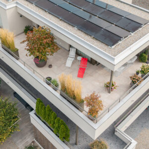 Dachterrasse mit Solarpaneelen und Pflanzen, von oben.