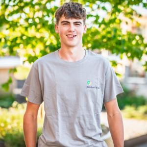 Junger Mann im Gartenarbeit-T-Shirt lächelt