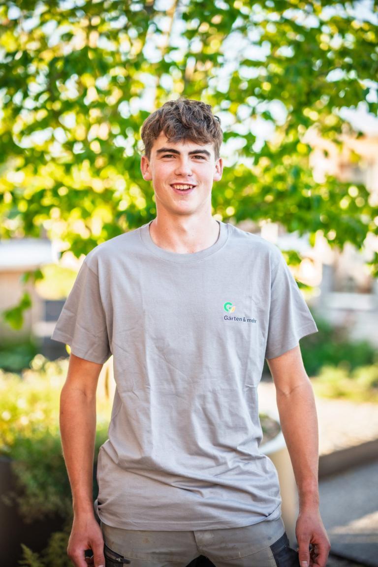 Junger Mann im Gartenarbeit-T-Shirt lächelt