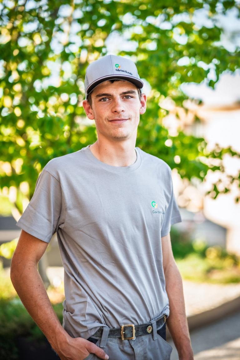 Mann im grauen T-Shirt vor grünem Hintergrund.