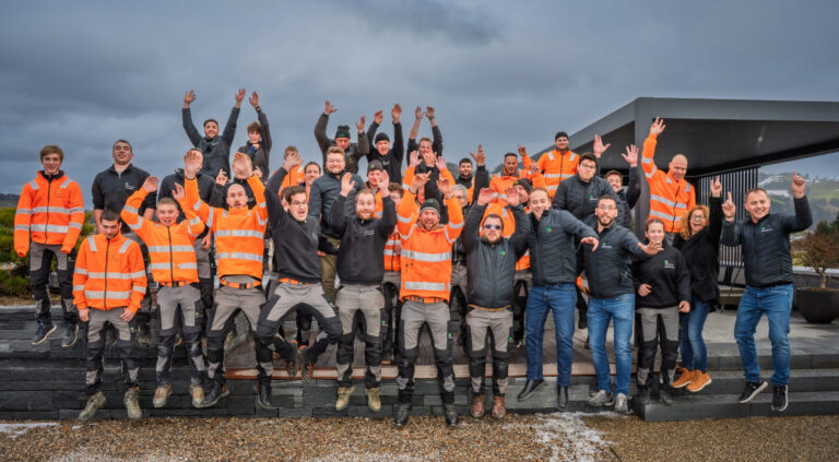 Gruppe von jubelnden Menschen in Arbeitskleidung.