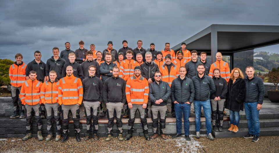 Gruppe von Arbeitern in orangenen Westen draußen.