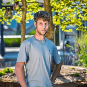 Junger Mann im Garten bei Sonnenlicht