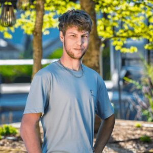 Junger Mann im Garten bei Sonnenlicht