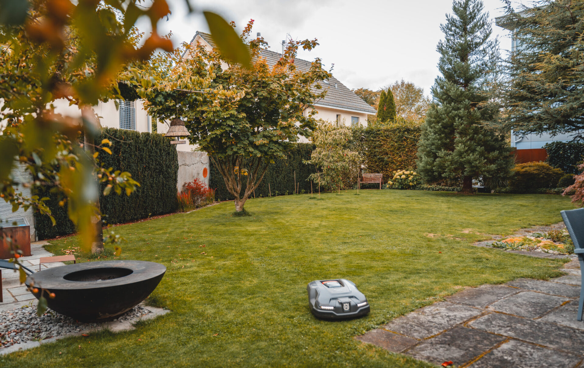 Garten mit Rasenmäher-Roboter und Bäumen