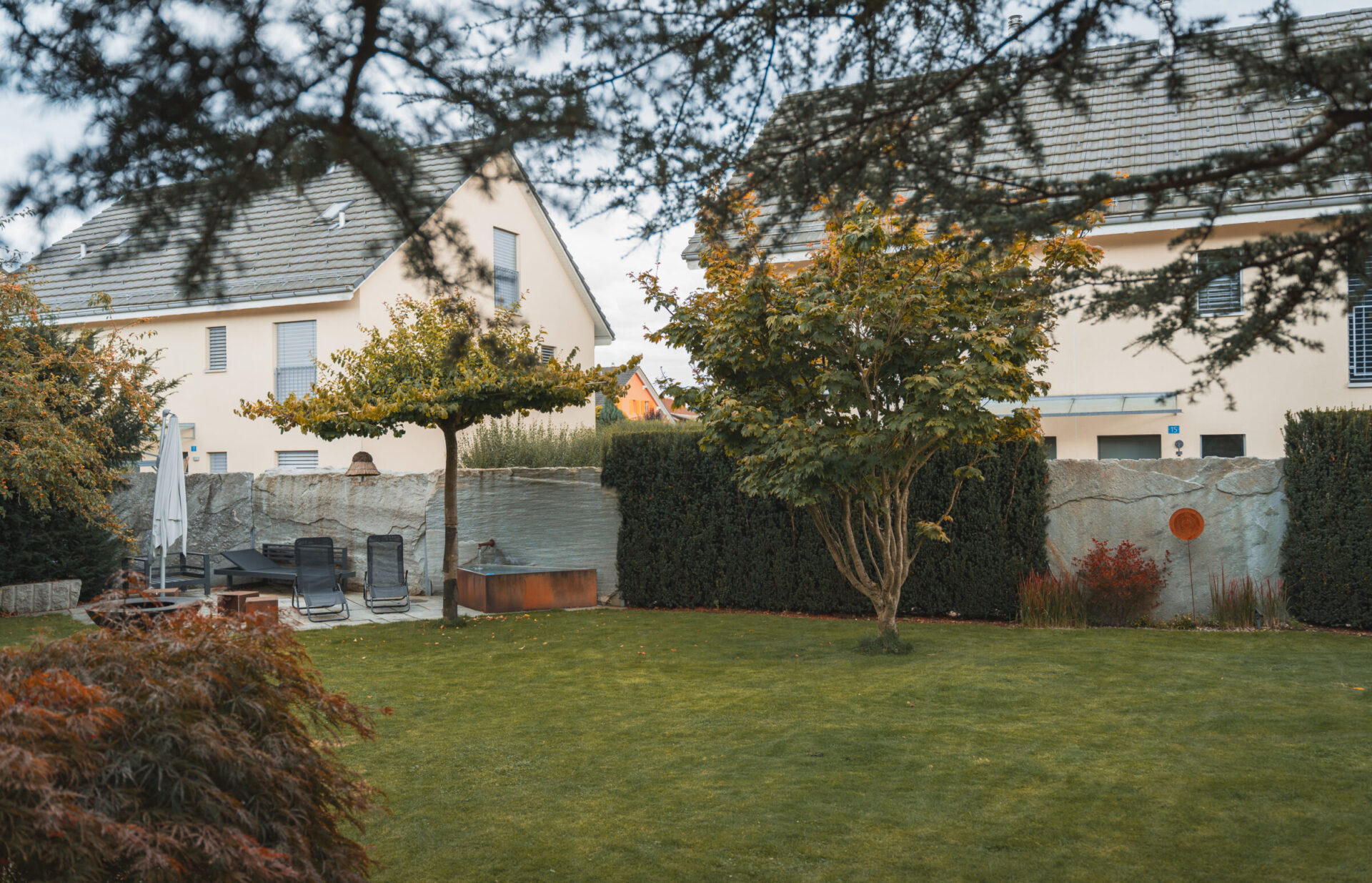 Gepflegter Garten mit Sitzbereich und Bäumen