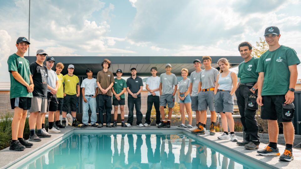 Team am Pool vor modernem Gebäude