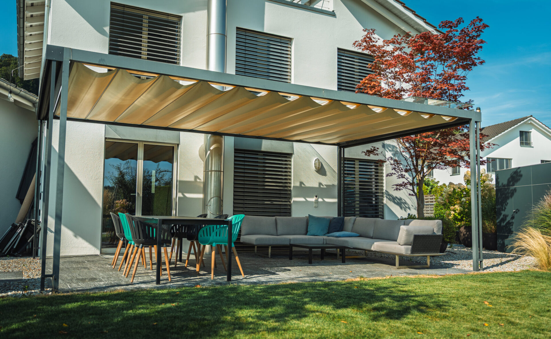 Moderne Terrasse mit Sofa und Tisch unter Pergola