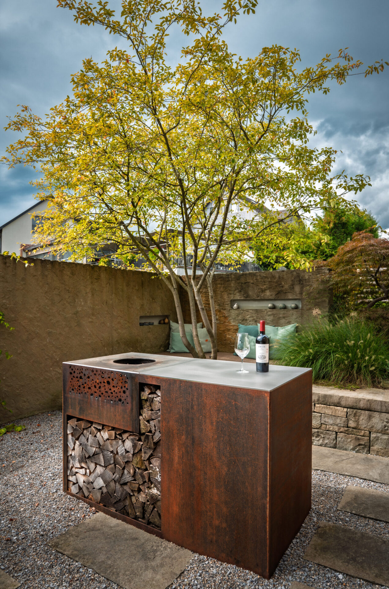 Gartenkamin mit Weinflasche und Glas im Freien