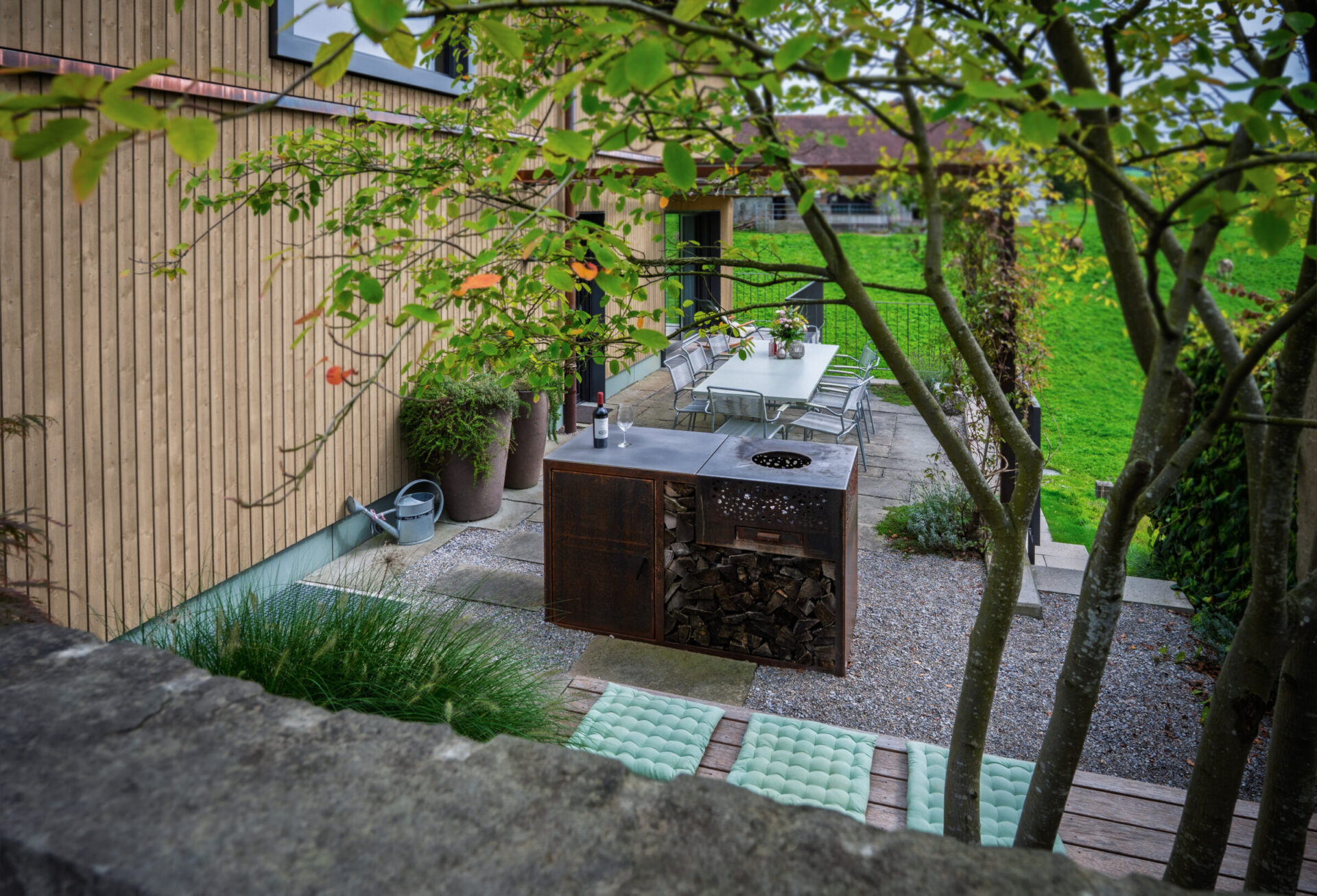 Garten mit Terrasse und Esstisch im Freien.