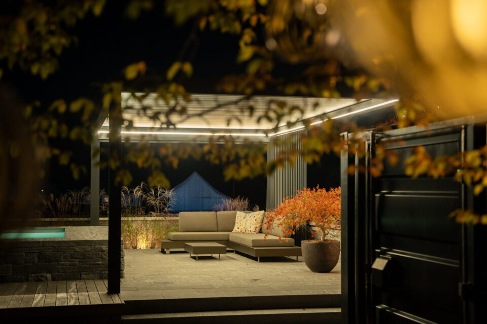 Nachts beleuchtete Terrasse mit Sofa und Pflanzen