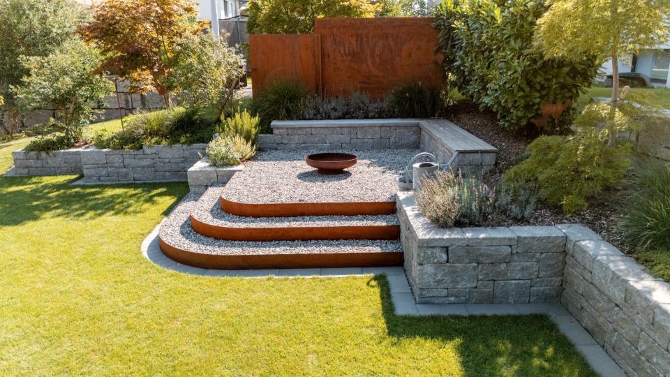 Gestufter Garten mit Feuerschale und Pflanzen