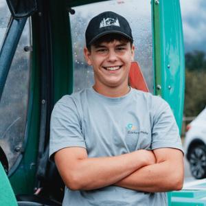 Lächelnder Mann vor grünem Traktor
