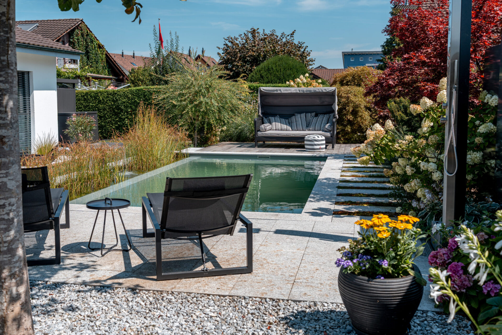 Moderner Garten mit Pool und Liegestühlen