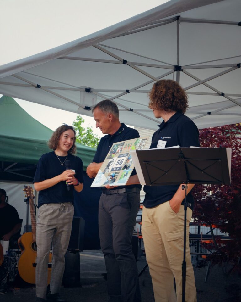 Drei Personen unter Pavillon bei einer Veranstaltung