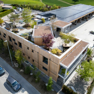 Gebäude mit begrüntem Dach und Solarpanelen von oben.