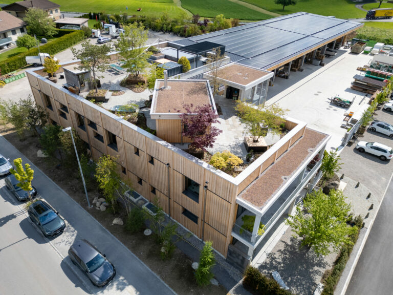 Gebäude mit begrüntem Dach und Solarpanelen von oben.