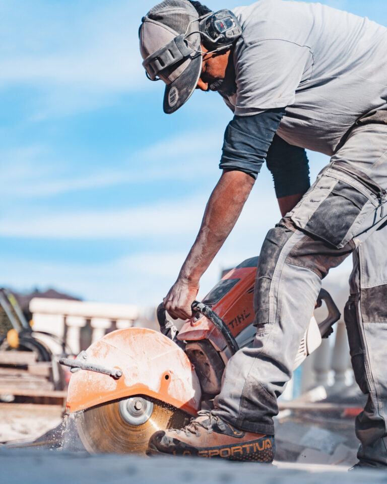 Arbeiter schneidet Holz mit Kreissäge.